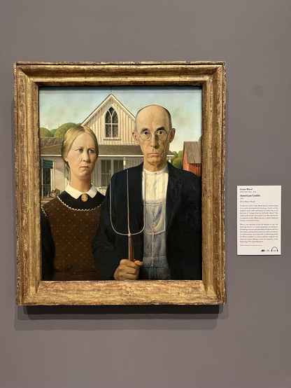Grant wood’s American Gothic painting in a frame at the art institute of Chicago