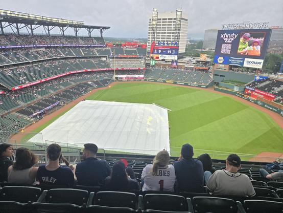 view of Trust Park from seats high up and behind first base.  the Tarp is on the field and it's raining.