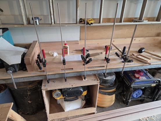 several pieces of wood glued and clamped on my workbench.  they are about 2" wide and high and about 36" long.