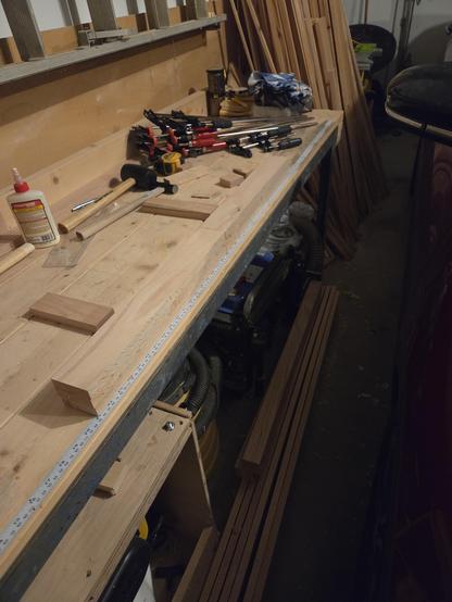 a 36" x 2.5" x 2.5" leg sits on a work bench. with a stack of clamps and some glue behind it.