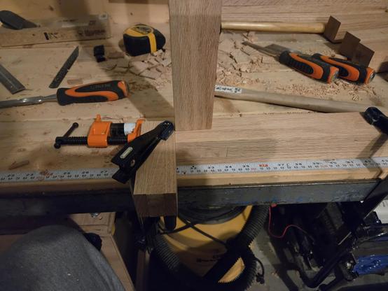 one mortise with a tenon fitted.  the whole assembly is clamped to the work bench.