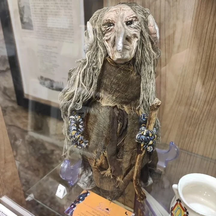 Frau Perchta  - a proud and terrifying mythical witch doll  with horns and long, beak-like nose proudly standing on a display in The Museum of Magic, Fortune-telling & Witchcraft in Edinburgh, Scotland.