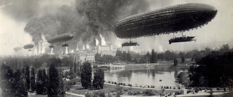 Zeppelins flying over a city with smoke rising in the background and a park with a body of water in the foreground.