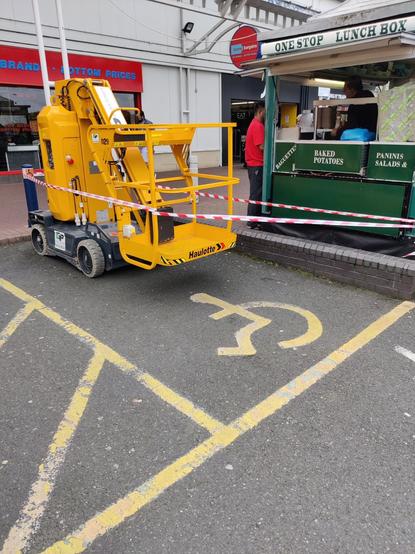 Self-propelled cherry-picker, parked in a disabled persons' parking bay