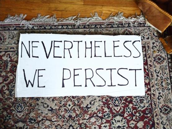 Image of a protest poster with the phrase "NEVERTHELESS WE PERSIST"