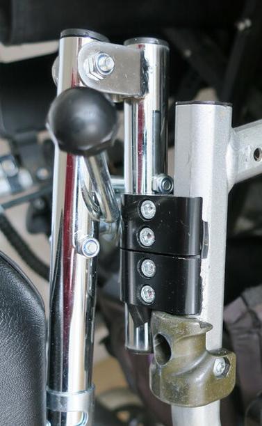 Two metal clips that connect a leg rest to a wheel chair.