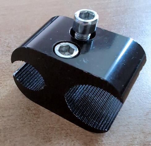 Metal clip to connect two metal tubes. Two cylinder screws press the clip together.