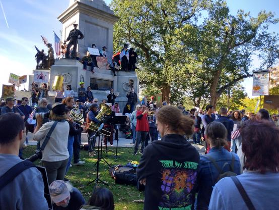 Five-person brass and drums combo playing at the NoKings rally in Boston.