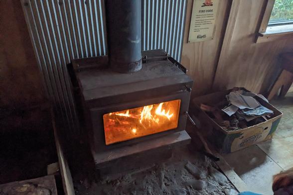Wood stove with a warm fire on a cool and rainy July day.