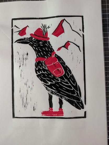 Black and red linoleum print. A black raven wearing a red hat, red backpack and red hiking boots. In the background there are black mountain silhouettes with red on the left-facing sides of the mountains.