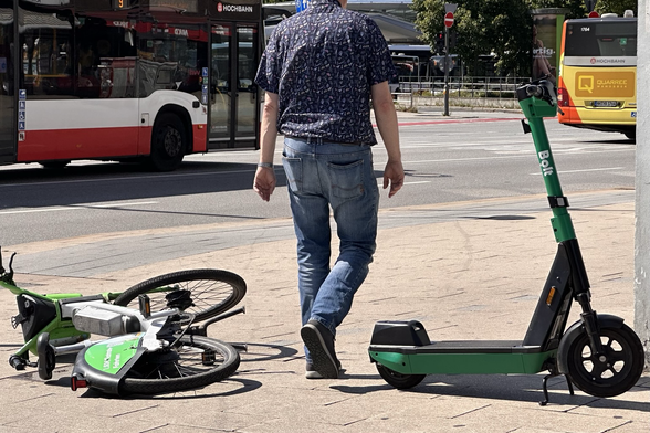 Umgestürztes Leihrad u senkrecht geparkter eScooter blockieren den Gehweg