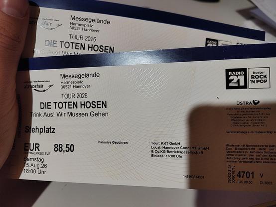Eine Hand, welche zwei Konzertickets hält.