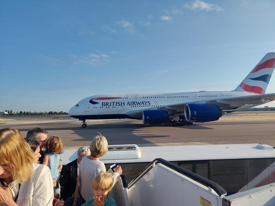 An A380 taxing to the runway. Taken from the top of an airplane staircase, so the left foreground is covered by people standing on said staircase.