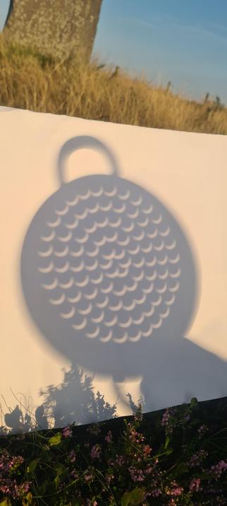 The veg steamer shadow on paper again, this time closer up. The holes are now even thinner crescents.