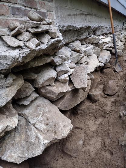 A fieldstone foundation with boulders that require a bar to move, exposed a little more than normal