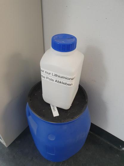 Ein Plastikbehälter, der offensichtlich für das Sammeln von alten Batterien gedacht ist, ist mit einem Label "Hier nur Lithiumionen" beschriftet