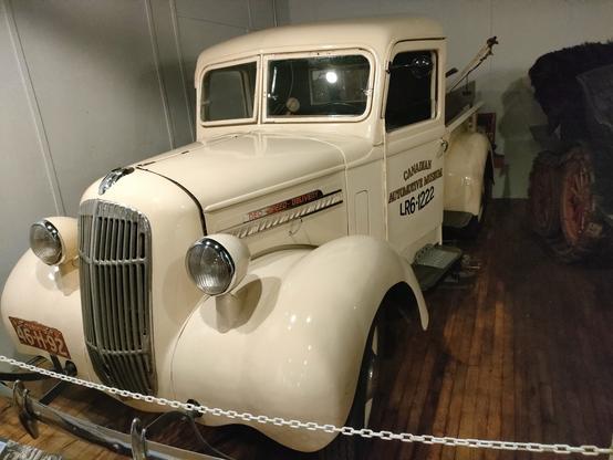 A cream coloured 1930s pickup truck, with "Canadian Automotive Museum LR6 1222" stenciled on the door.