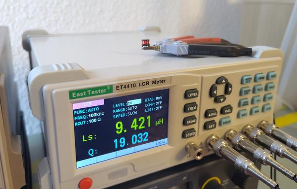 A bench LCR meter measuring an inductor. The LCR meter shows 9.421uH