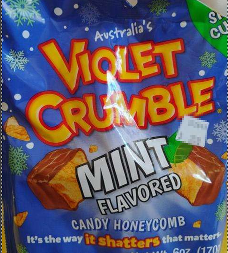 Image of bag of candy, predominant color dark blue, with scattered snowflakes, with text: "Australia's Violet Crumble / Mint flavored Candy Honey comb" with motto "It's the way it shatters that matters".
