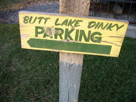 A hand-painted wood sign reads "BUTT LAKE DINKY PARKING."