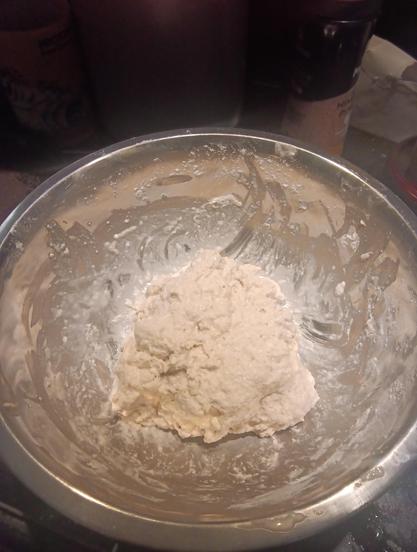 gloopy ball of dough in a metal mixing bowl