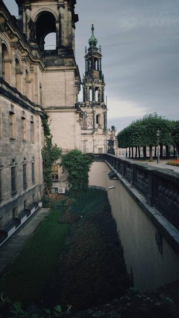 A church and an old fortification below grey clouds.