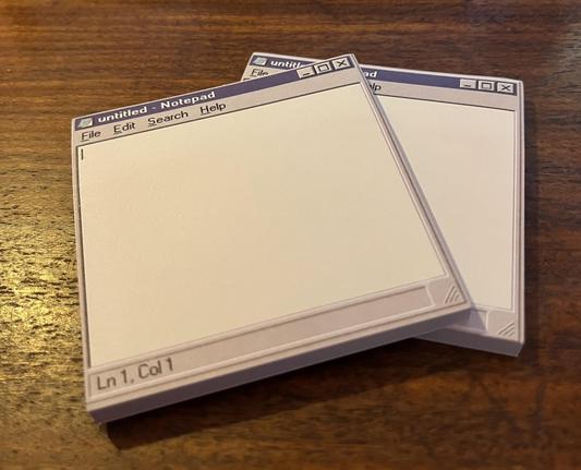Photograph of two small pads of sticky notes, sitting on a wooden desk. The notes look exactly like NOTEPAD.EXE running on Windows 95 and are the SILLIEST THING EVER.