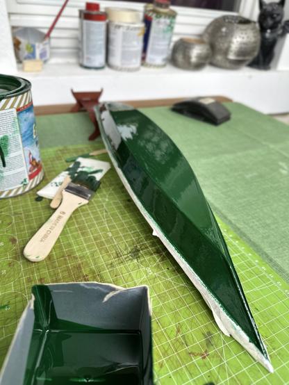 Second coat of varnish onto the hull. Boat upside down with tape on the wooden areas