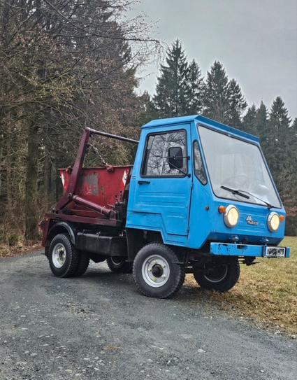 Ein blauer Multicar mit roter Mulde