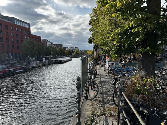 A canal and bikes in Belgium with trees lining the way