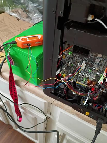 a flipper zero next to a 3d printer motherboard with a 4 pin connector attached by three colored wires plugged into the GPIO ports