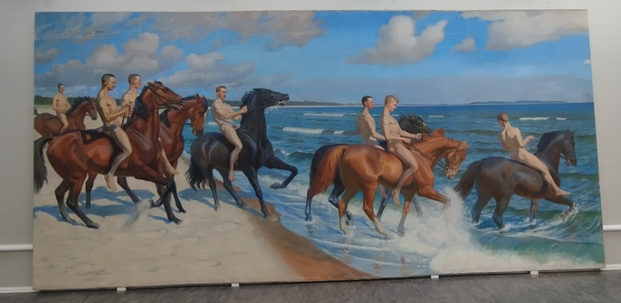 Naked riding horses on a sandy beach into the sea.