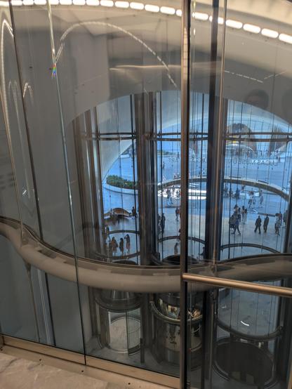 Inside a glass elevator, overlooking the lobby of the Lucas Museum