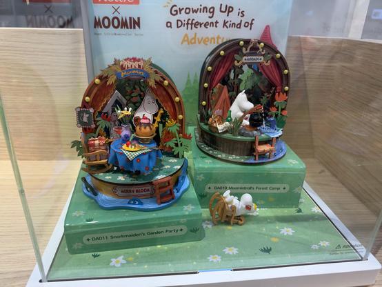 Two small Moomin diorama. One is a cake party and the other is Moomin next to a streaming fishing