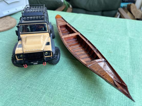 Trx4m model of a yellow landrover defender next to the sandolo from top front.