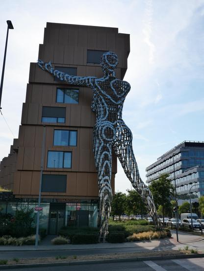Apartment building with a giant (8 floors) metal statue of a female figure holding the building between her arms.