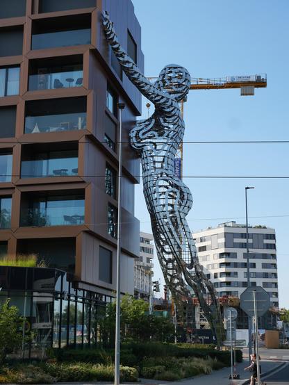 Apartment building with a giant (8 floors) metal statue of a female figure holding the building between her arms.