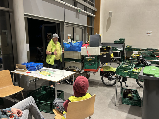 some* foodsharer in Element vor einem übervoll geladenem Anhänger an einem Faltrad
