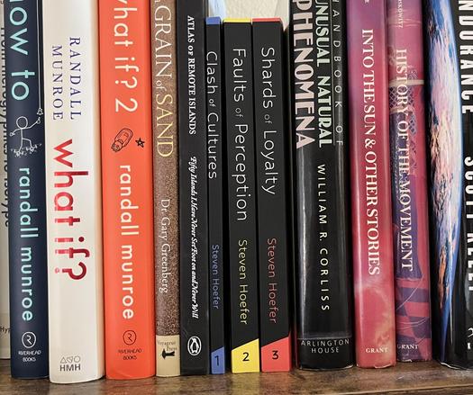 A photo of a bookshelf, with three matching paperbacks in the middle. Clash of Cultures, 1, Faults of Perception, 2, and Shards of Loyalty, 3. All written by Steven Hoefer. Hey, that's me!
