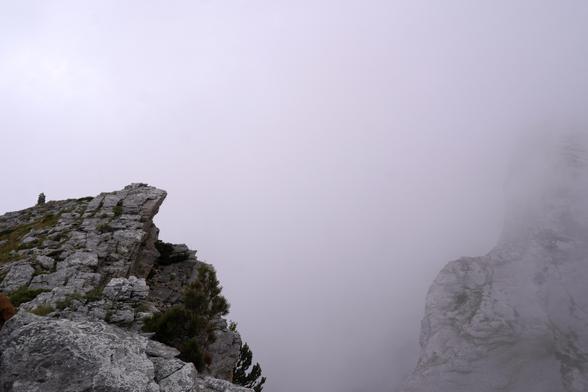 More gray. To the left, the top of a cliff. Then just cloud, and some rock to the right.