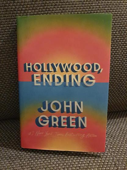 Photo of the book Hollywood, Ending by John Green. The cover of this hardcover edition shows a color gradient between green, red and orange colors, with a sharp line in the middle