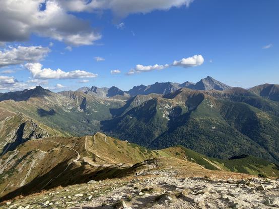 Panoramic view of the High Tatras (Eastern part) from the top of Kopa Kondracka. Behind the nice grassy mountains in the foreground the further rows of them are increasingly gray, rocky and unfriendly looking. The biggest stony peak on the right is Slovakian Kryvan.