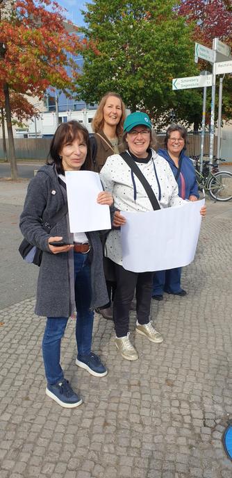 Vier Frauen aus Charlottenburg nebeneinander

Im Hintergrund das Kanzleramt

Corinna trägt eine grüne Mütze