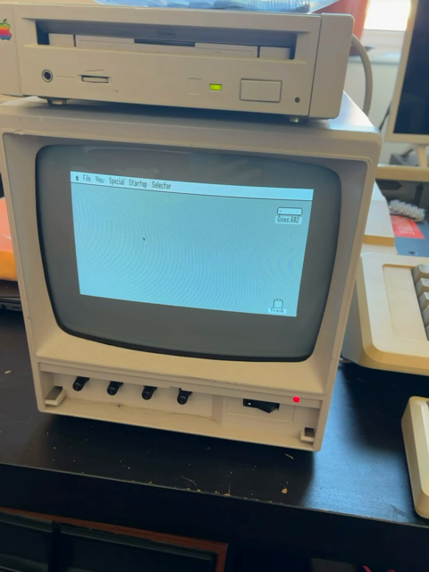 A short video of a small black and white CRT with an appleCD disk drive on top.

The system boots into the Apple ii desktop (think Mac OS desktop from the 80s), and the mouse is happily responding!