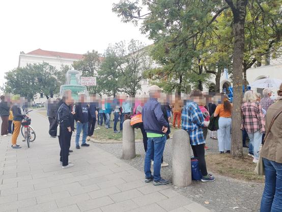 Vielr Menschen stehen vorm Brunnen am Geschwister-Scholl-Platz bei der Abschlusskundgebung. Auf einem Plakat steht: Autoverkehr ist heilbar.