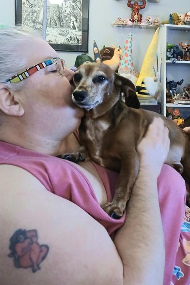 I'm a white woman with Bucky, a senior red dachshund, in my face. He had his face pressed into mine getting kisses on his snout. He was like this for 30 minutes.
