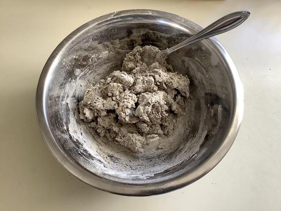 A chunky mixture of rye flour and buttermilk in a small stainless steel bowl.