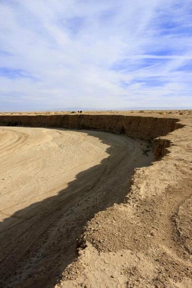 This desert photo highlights the sharp, crumbling rim of an eroded basin.