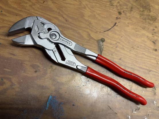 Knipex smooth-jawed pliers with red handles, still shiny new, sits on my workbench.