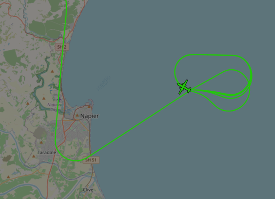 A flight tracking map showing Air New Zealand ATR-72-600 aircraft in a holding pattern off the coast ahead of an emergency landing at Napier Airport.